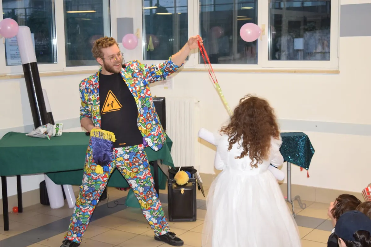 Una bambina vestita per la comunione partecipa alla magia