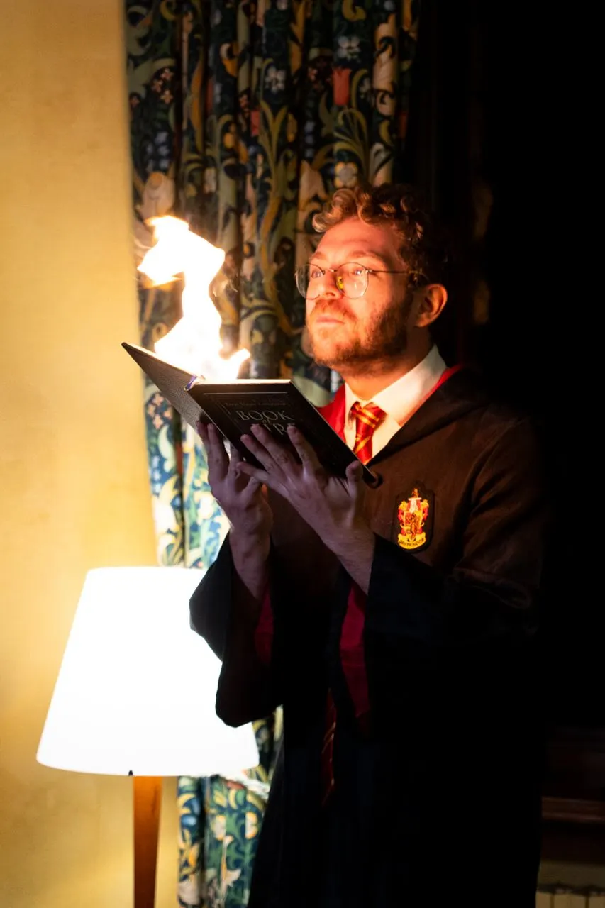 Mattia in tunica da mago con un libro che prende fuoco
