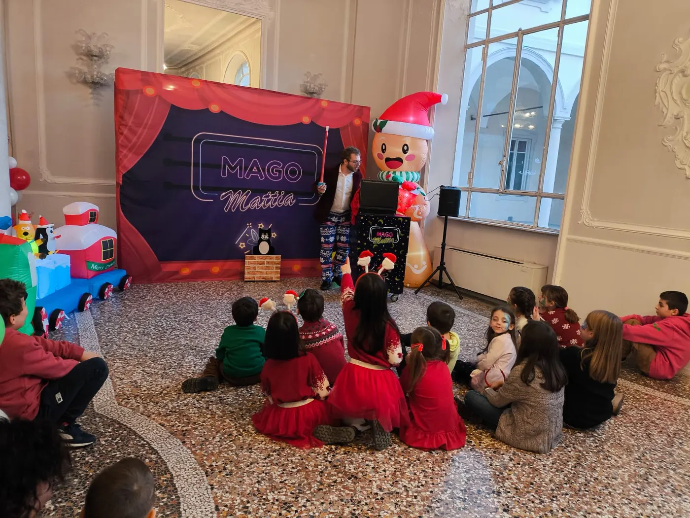Bambini seduti davanti allo spettacolo di magia di Natale